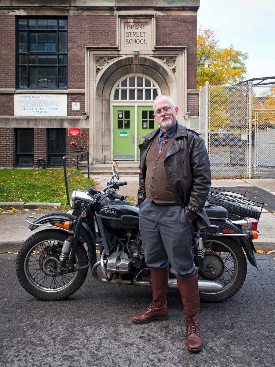 Jamie Leonard stands in front of his sidecar motorcycle parked in front of Alpha Alternative School