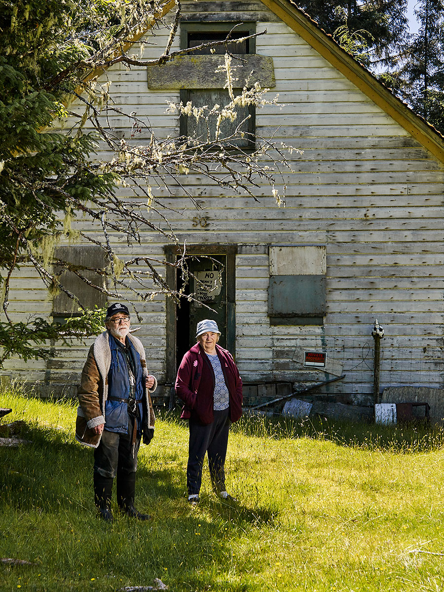James "Jimmy" Michael Poulton and Nancy Olga Poulton/Lanqvist stand in front of the house they used to live with their mother "Toots" (Johanna Laura Poulton) over 50 years ago. Built in 1904 on this site on Rauhala heritage farm, it is one of the last buildings still standing built by the Kalavan Kanssa Finnish settlers. Nancy's son Roger Léo Lanqvist hopes to restore the building and turn it into a museum. Sointula, British Columbia.