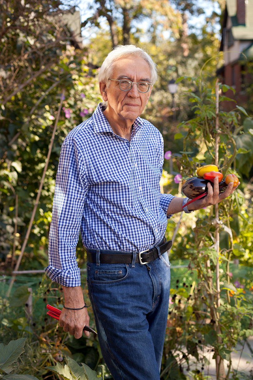 John Sharkey holds vegetables and garden shears in his garden in the Bain Co-op.