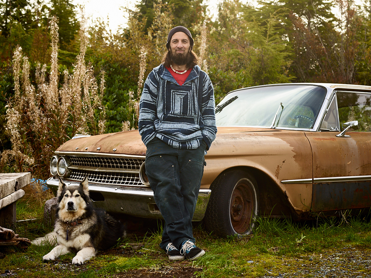 Grant McCormick with his ten-year old dog Luna and the 1961 Ford Galaxy he's planning to restore one day. Sointula, British Columbia.