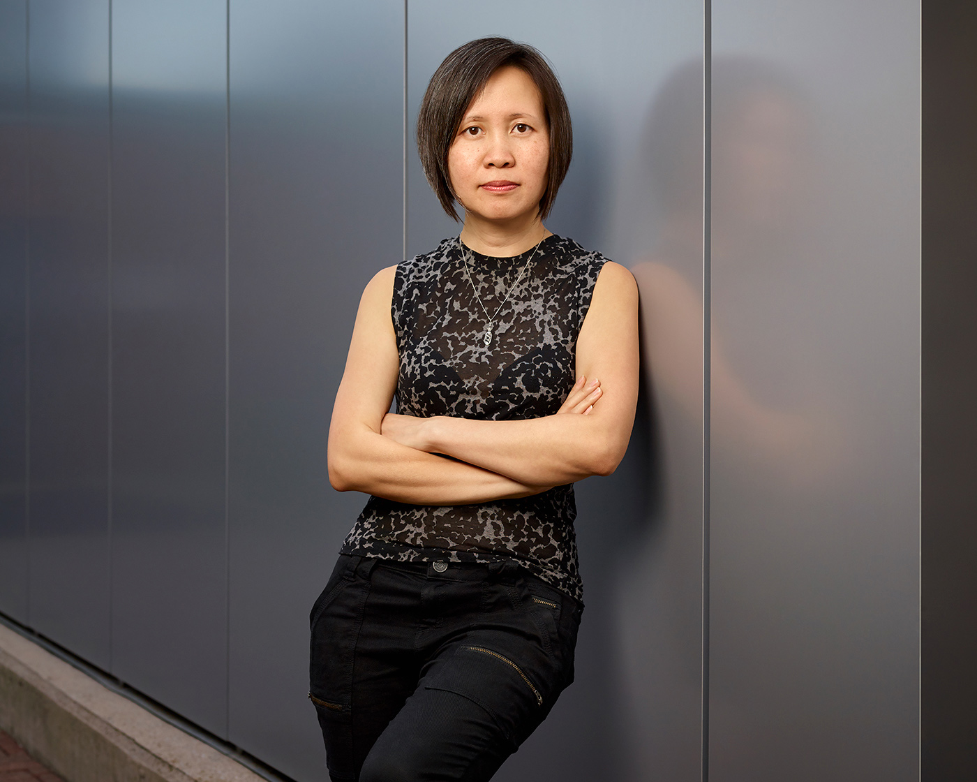 Image of cinematographer Iris Ng leaning against a wall with her arms folded.